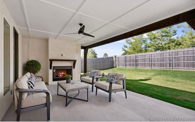 view of patio / terrace with ceiling fan and an outdoor living space with a fireplace