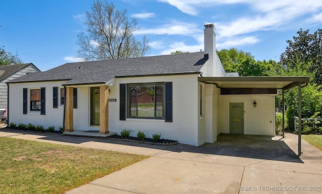 3006 E 21st St, Tulsa, OK 74114 - view of front of home featuring driveway, brick siding, an attached carport, and a front yard