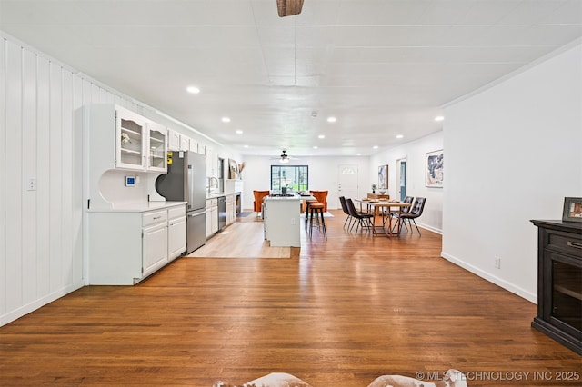 3006 E 21st St, Tulsa, OK 74114 - kitchen featuring a ceiling fan, appliances with stainless steel finishes, wood finished floors, white cabinets, and light countertops