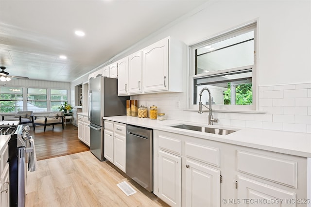 3006 E 21st St, Tulsa, OK 74114 - kitchen featuring stainless steel appliances, healthy amount of natural light, white cabinets, tasteful backsplash, and recessed lighting