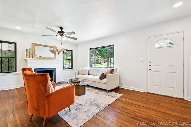 3006 E 21st St, Tulsa, OK 74114 - living area with wood finished floors, a fireplace with flush hearth, a ceiling fan, recessed lighting, and ornamental molding