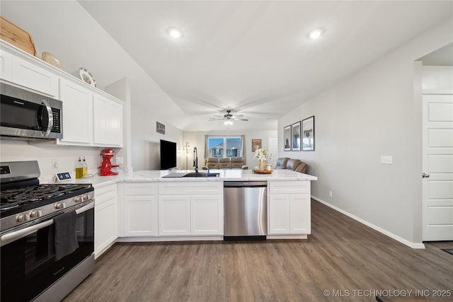 kitchen featuring stainless steel appliances, white cabinetry, sink, and kitchen peninsula