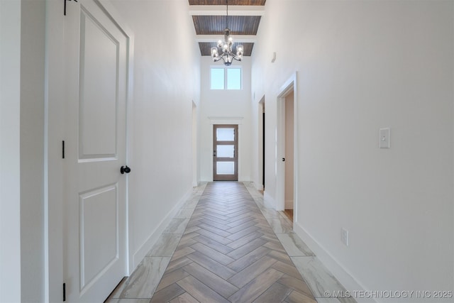 2044 E 129th Pl S, Jenks, OK 74037 - entryway with a chandelier, baseboards, a high ceiling, and wooden ceiling with exposed beams