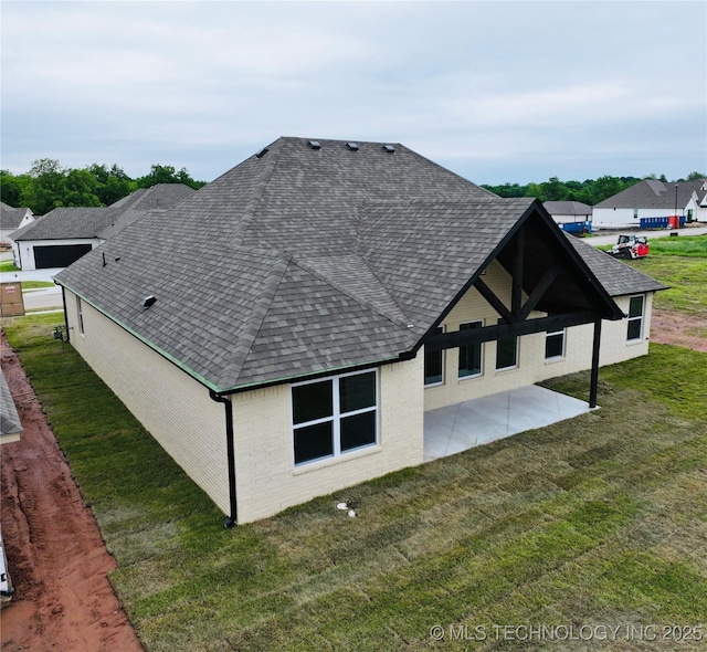 2044 E 129th Pl S, Jenks, OK 74037 - back of house featuring roof with shingles, a patio area, brick siding, and a yard