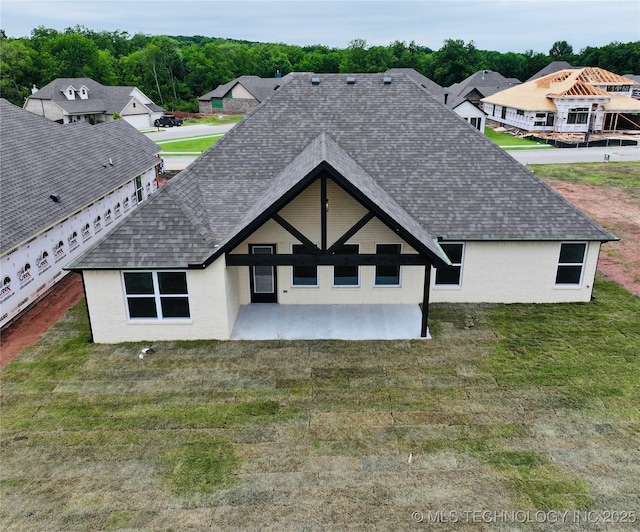 2044 E 129th Pl S, Jenks, OK 74037 - back of property with roof with shingles, a patio area, brick siding, and a yard