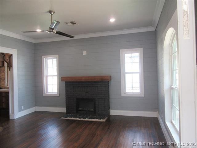 unfurnished living room with a brick fireplace, crown molding, and dark hardwood / wood-style floors