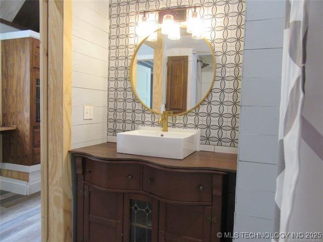 bathroom featuring vanity, decorative backsplash, and wooden walls