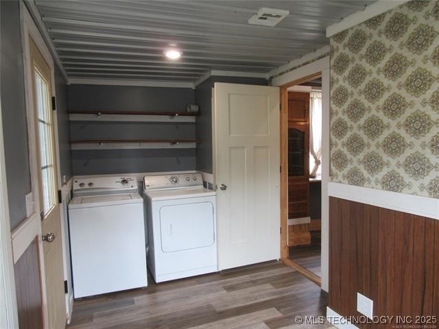 washroom with hardwood / wood-style flooring and separate washer and dryer