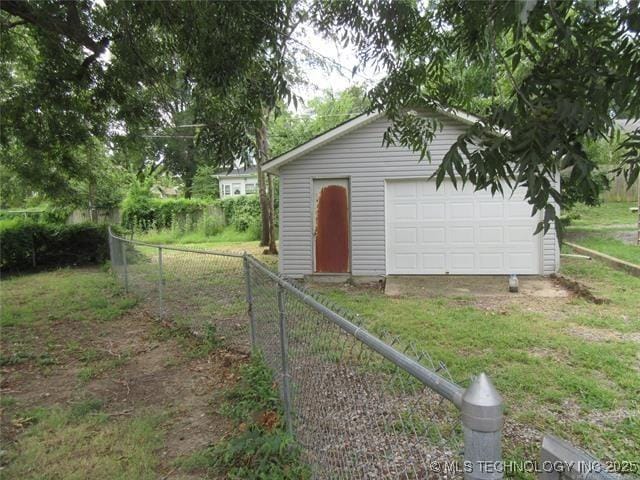 view of outbuilding featuring a garage and a lawn