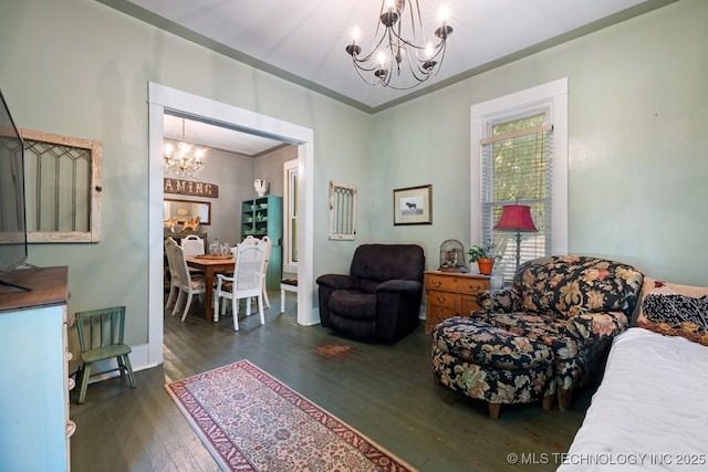 living room featuring ornamental molding, a notable chandelier, and dark hardwood / wood-style flooring