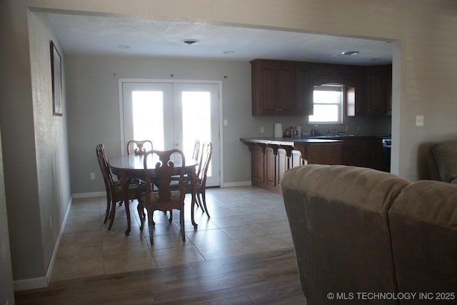 dining area with light hardwood / wood-style flooring and french doors