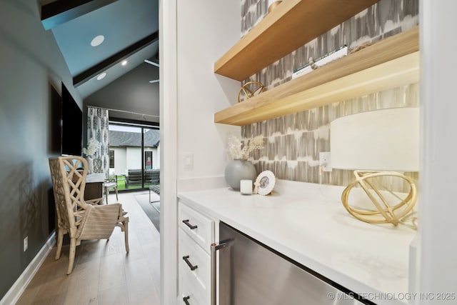 bar featuring light wood-type flooring, vaulted ceiling, white cabinets, and beverage cooler