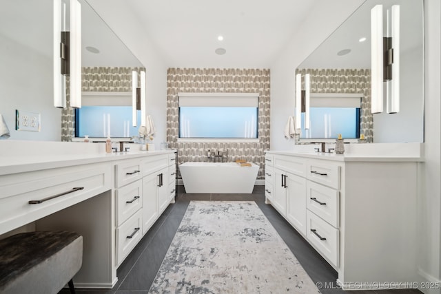 bathroom with a tub and vanity