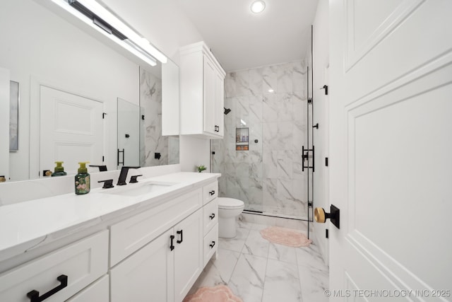 bathroom with toilet, vanity, and a shower with shower door