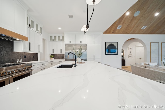 kitchen with sink, pendant lighting, white cabinetry, and light stone countertops