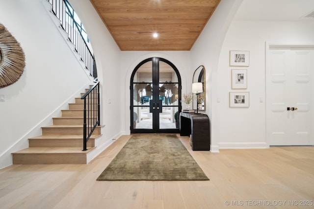 entryway with light wood-type flooring, french doors, and wood ceiling