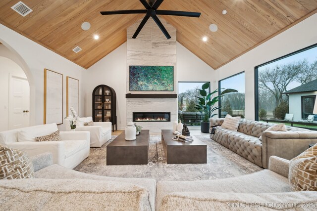 living room featuring ceiling fan, high vaulted ceiling, a large fireplace, and wooden ceiling