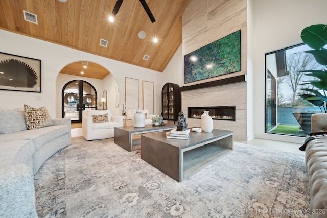 living room featuring a large fireplace, high vaulted ceiling, and wooden ceiling