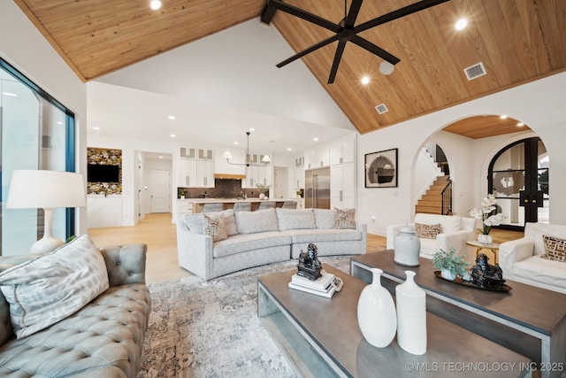 living room featuring light hardwood / wood-style floors, high vaulted ceiling, ceiling fan, and wood ceiling