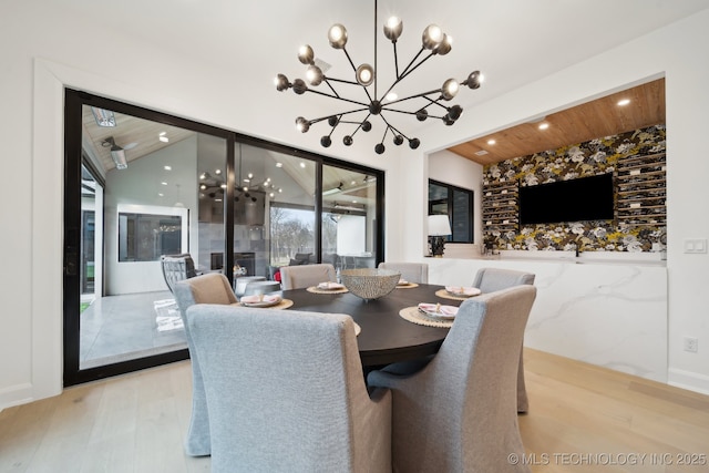 dining area with a notable chandelier, light wood-type flooring, vaulted ceiling, and wooden ceiling