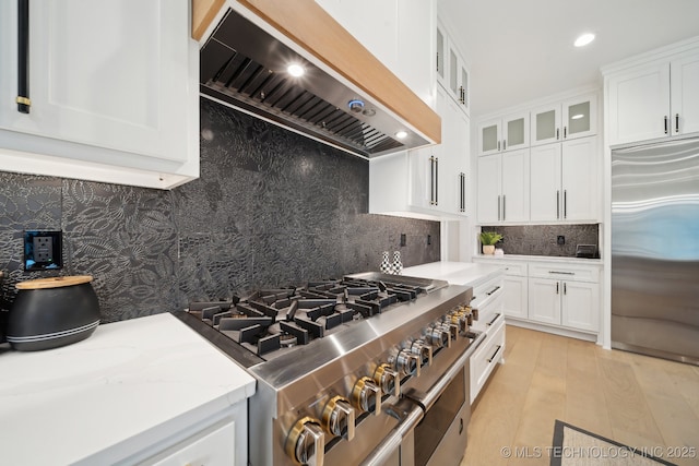7300 E College St, Broken Arrow, OK 74014 - kitchen with custom range hood, high end appliances, white cabinets, glass insert cabinets, and backsplash
