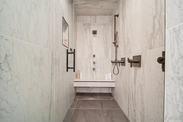 bathroom with tile walls and tiled shower