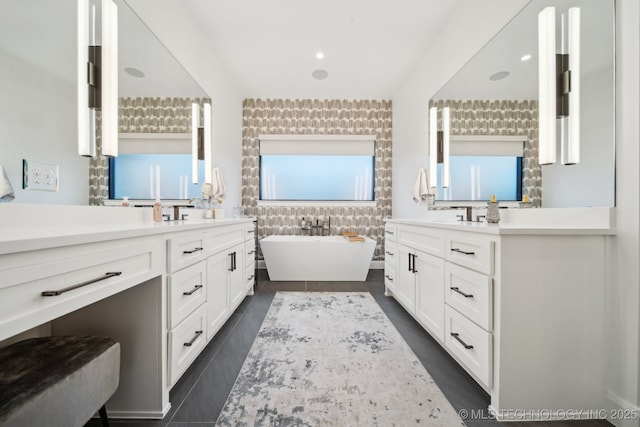 7300 E College St, Broken Arrow, OK 74014 - bathroom featuring two vanities, a freestanding tub, tile walls, and tile patterned floors