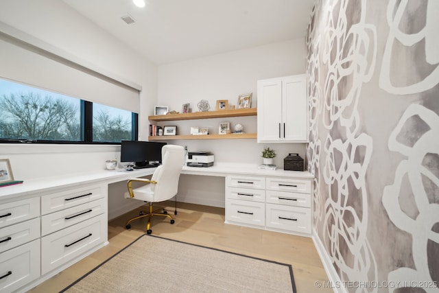 office featuring light hardwood / wood-style floors and built in desk