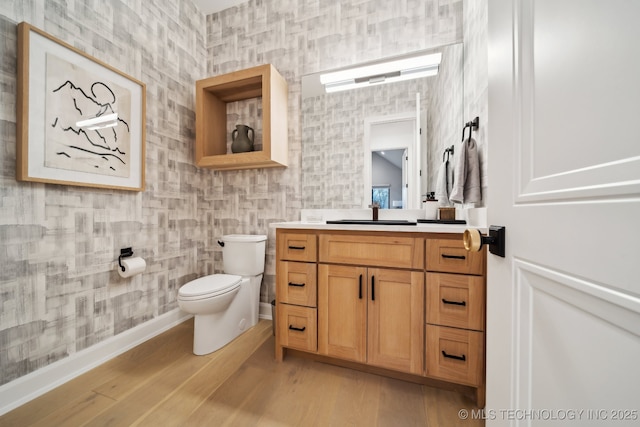 bathroom featuring wood-type flooring, vanity, and toilet