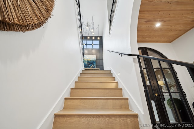 stairs featuring wood ceiling and a towering ceiling