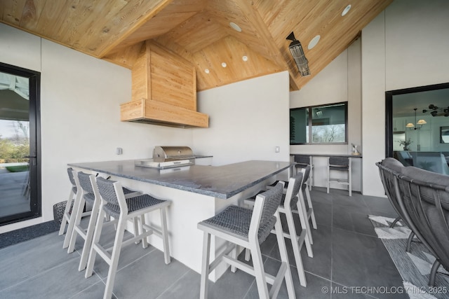 7300 E College St, Broken Arrow, OK 74014 - kitchen with wood ceiling, lofted ceiling, a kitchen bar, dark tile patterned flooring, and recessed lighting