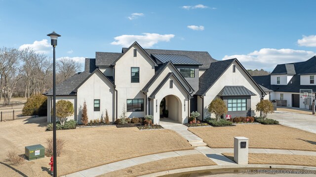 view of front facade featuring a standing seam roof, metal roof, and stucco siding