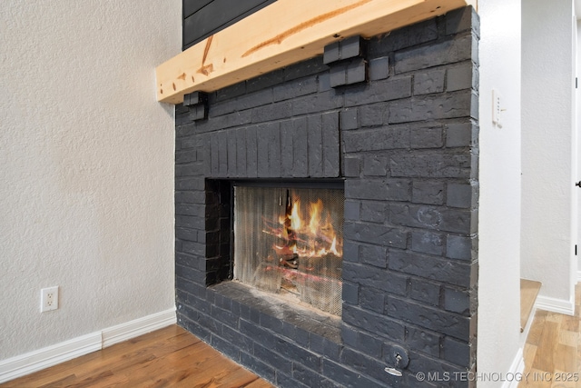 details featuring a brick fireplace and hardwood / wood-style floors