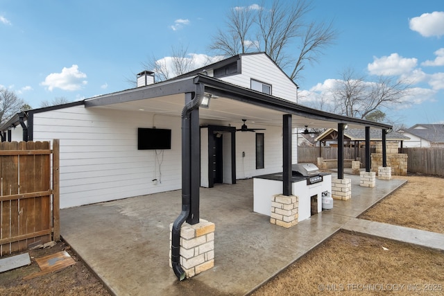 view of patio featuring ceiling fan, a grill, and exterior kitchen