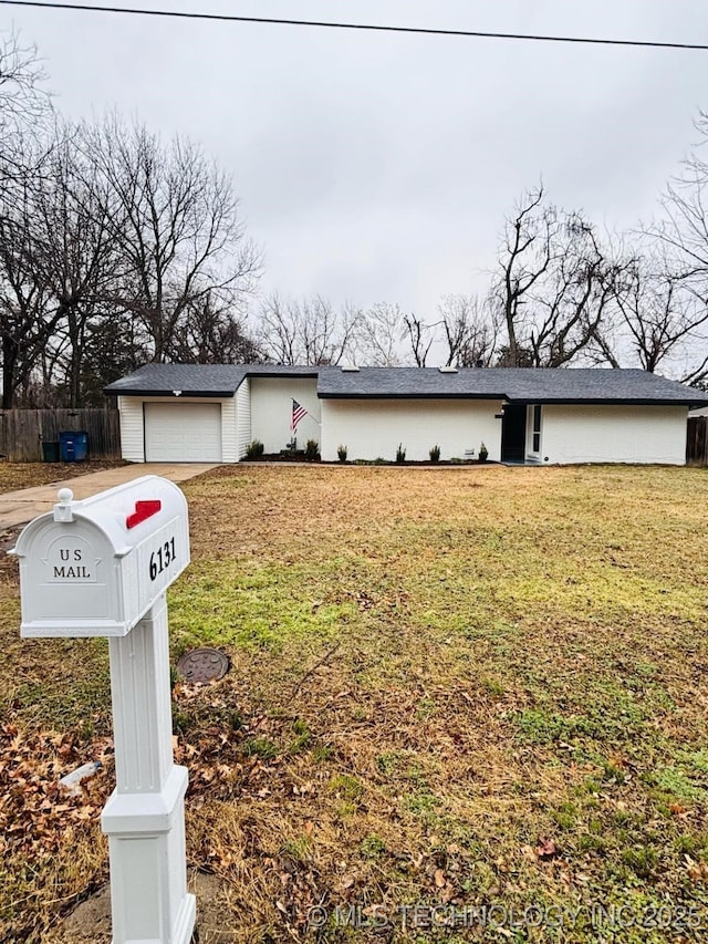 ranch-style house with a garage and a front yard