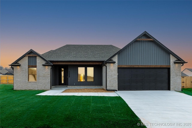 view of front of home with a garage and a lawn