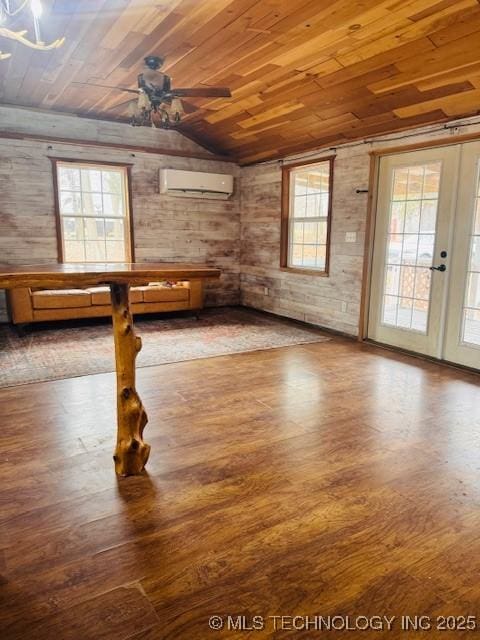 empty room featuring wood ceiling, vaulted ceiling, an AC wall unit, hardwood / wood-style flooring, and ceiling fan