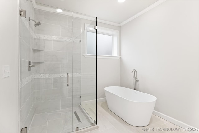 bathroom featuring ornamental molding and separate shower and tub