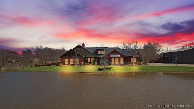 craftsman inspired home featuring a water view and a yard