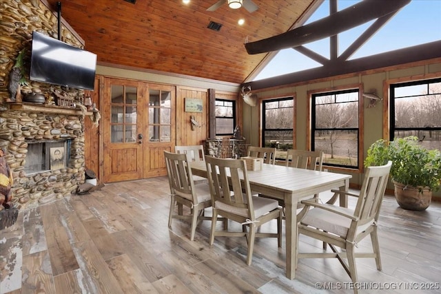 dining space with high vaulted ceiling, a fireplace, light hardwood / wood-style floors, wooden ceiling, and french doors