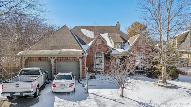 view of front of property with brick siding, a chimney, a shingled roof, a garage, and driveway