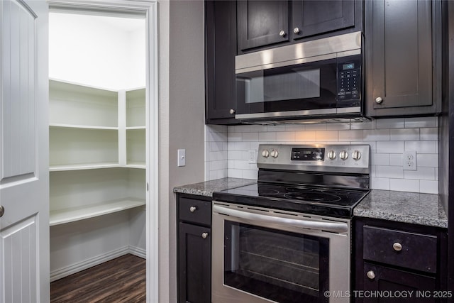 kitchen featuring dark hardwood / wood-style flooring, stainless steel appliances, light stone countertops, and backsplash