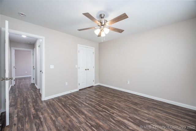 unfurnished bedroom featuring ceiling fan, a closet, and dark hardwood / wood-style flooring