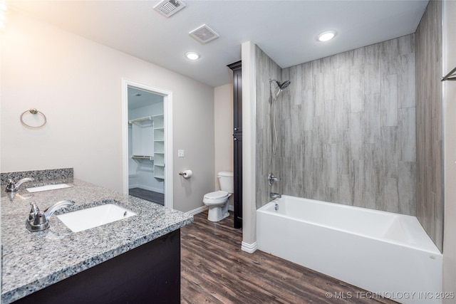 full bathroom with tiled shower / bath combo, vanity, toilet, and hardwood / wood-style floors