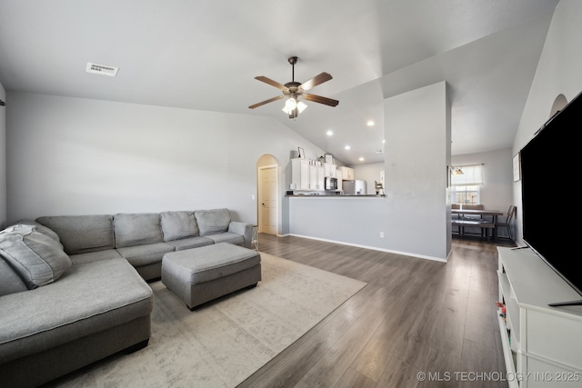 living area with visible vents, arched walkways, lofted ceiling, ceiling fan, and wood finished floors