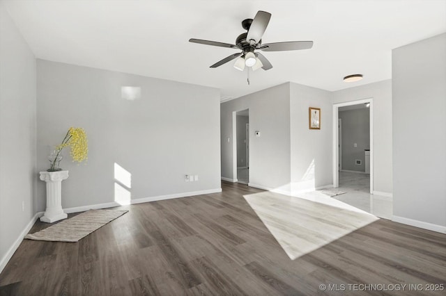 interior space featuring a ceiling fan, baseboards, and wood finished floors