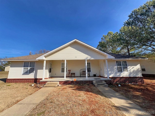 ranch-style house featuring a porch and a front lawn