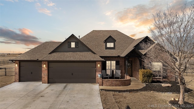 view of front of property featuring driveway, brick siding, a garage, and roof with shingles