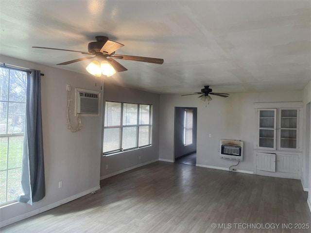 unfurnished living room with ceiling fan, dark hardwood / wood-style floors, heating unit, and an AC wall unit