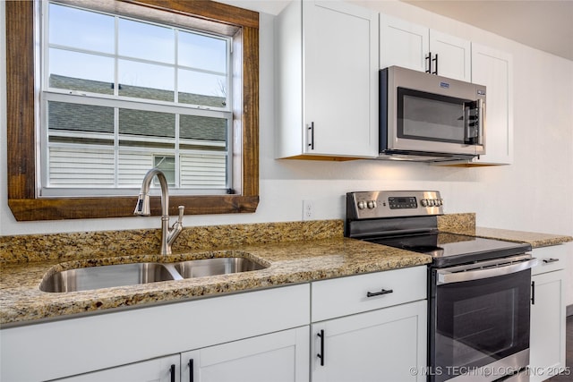 719 W Evergreen, Durant, OK 74701 - kitchen featuring white cabinetry, stainless steel appliances, a sink, and light stone countertops